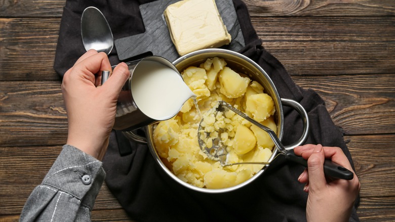 pouring milk into mashed potatoes