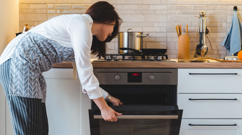 woman opening oven door