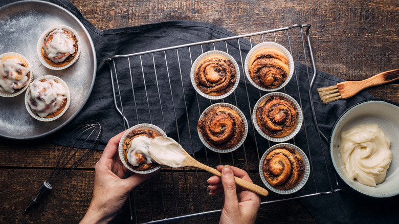 hand icing cinnamon muffins