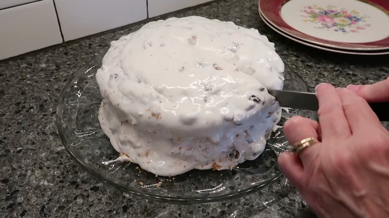 Person slicing a Lady Baltimore cake