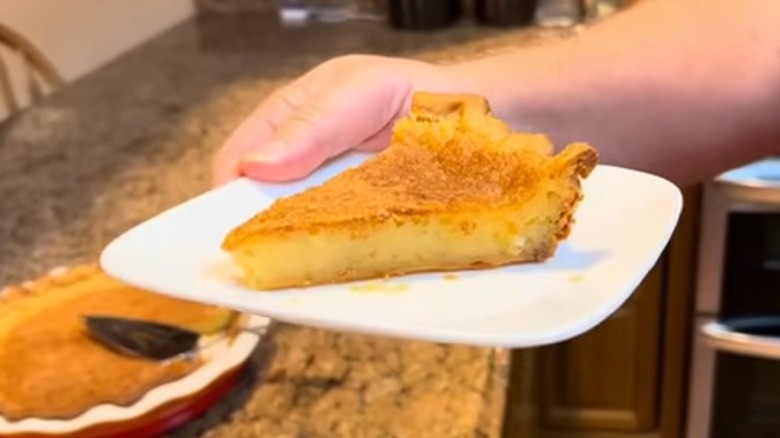 Person holding a square white plate of transparent pie