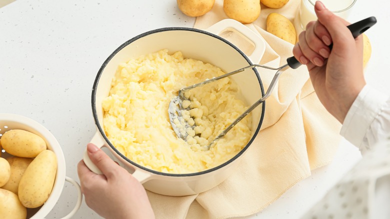 Person mashing potatoes