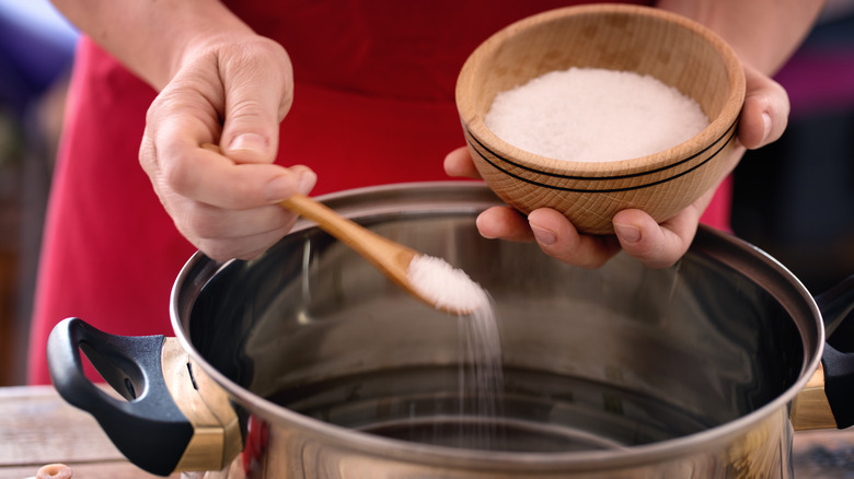 adding salt to pot