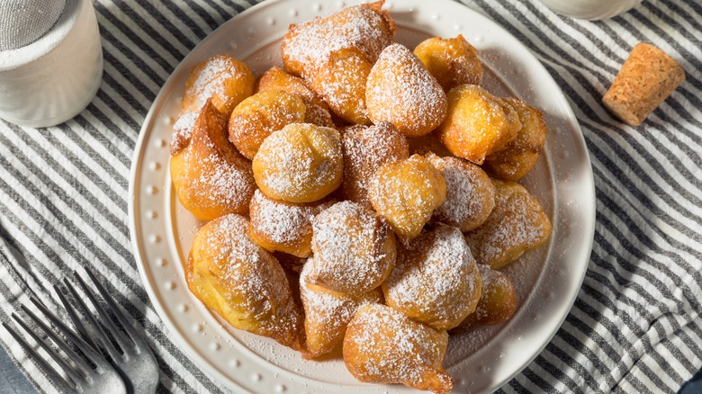 Powdered zeppole on white plate