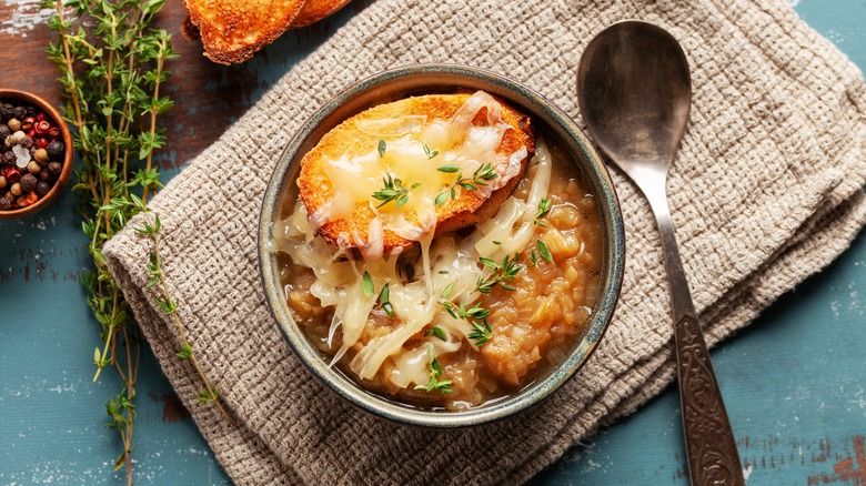 French onion soup in a grey bowl topped with cheesy croutons