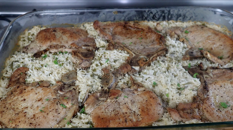 a baking dish filled with pork chop and rice casserole