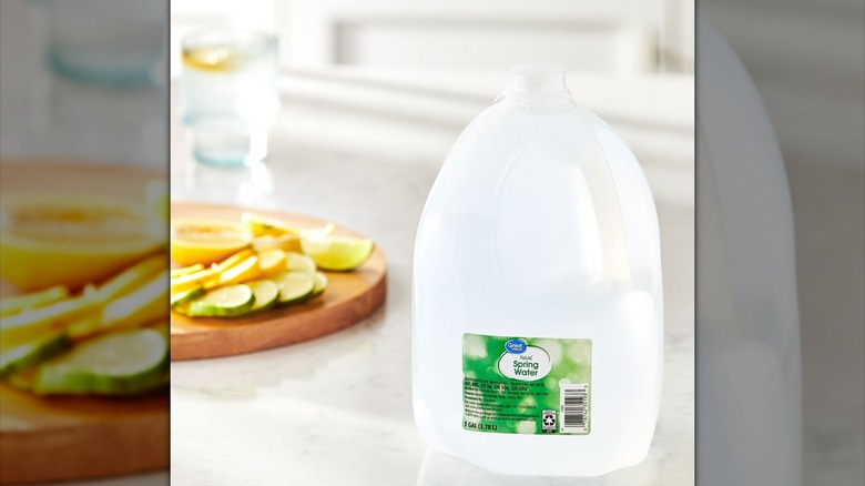 A gallon jug of great value spring water on a home counter with fresh fruit slices