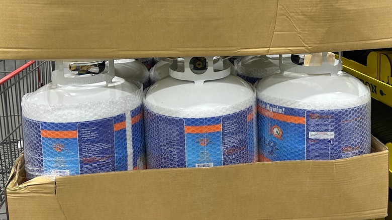 Several Flame King Max Empty Steel Propane Cylinder with OPD Valve & Gauge sitting in cardboard crates