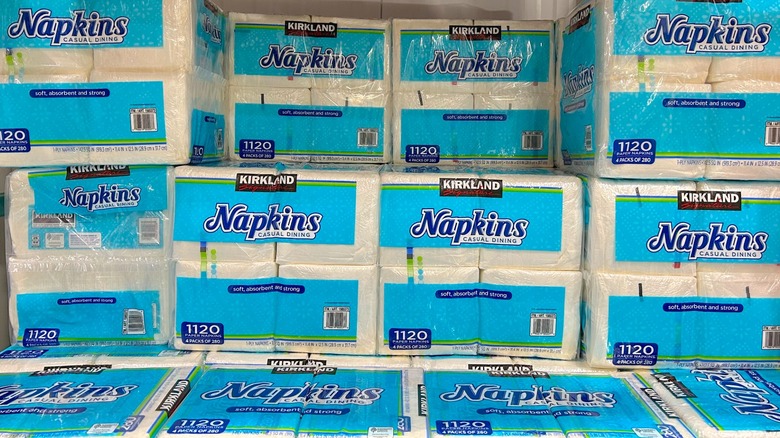 Several packages of Kirkland Signature Dining Napkins stacked up