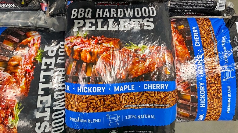 Multiple bags of Kirkland Signature Premium Blend BBQ Hardwood Pellets stacked on top of one another