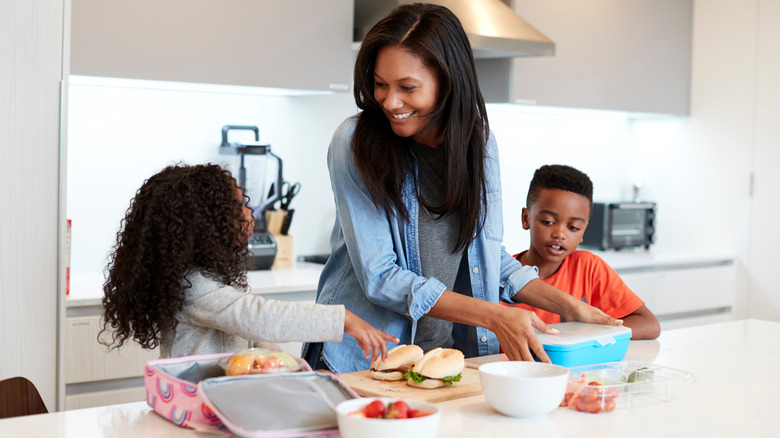 mother and children packing school lunch