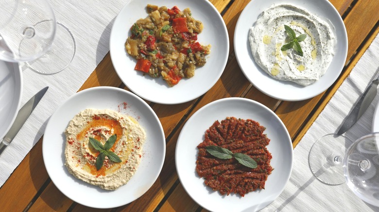 White bowls with assorted Mediterranean dips