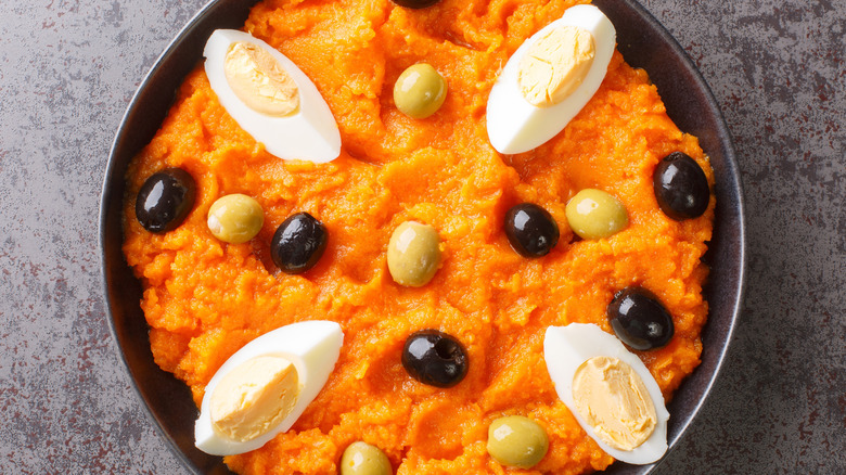 Bowl of Omek Houria garnished with olives and egg slices