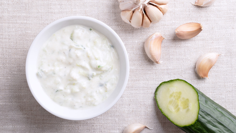 Bowl of tzatziki surrounded by its ingredients