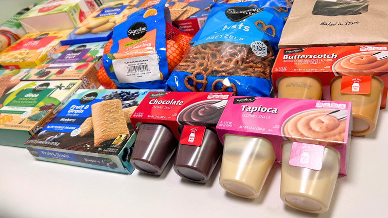Many Signature Select snacks on a white and green background