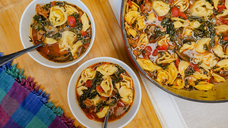 Two white bowls of Sausage And Spinach Tortellini Soup