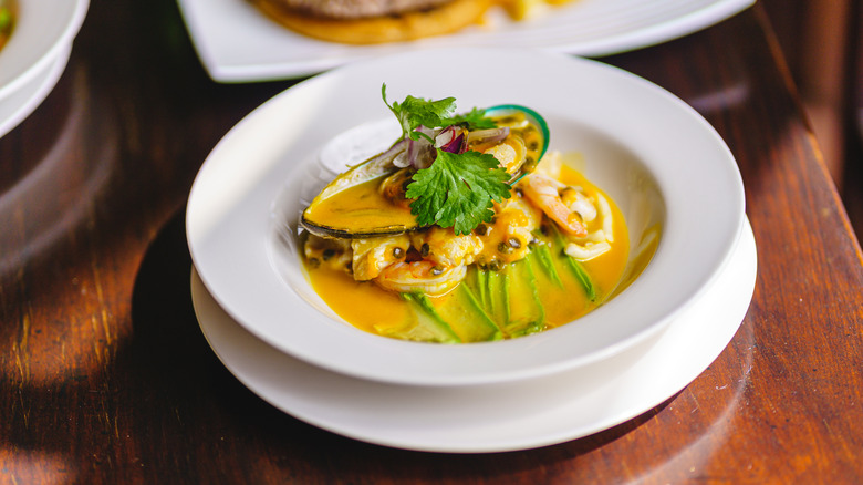 Ceviche in a white bowl on a wooden table