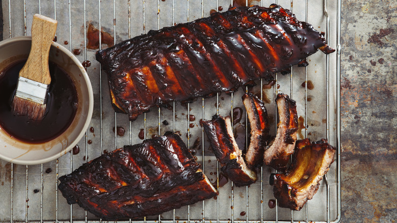 BBQ pork ribs next to a small dish of barbecue sauce