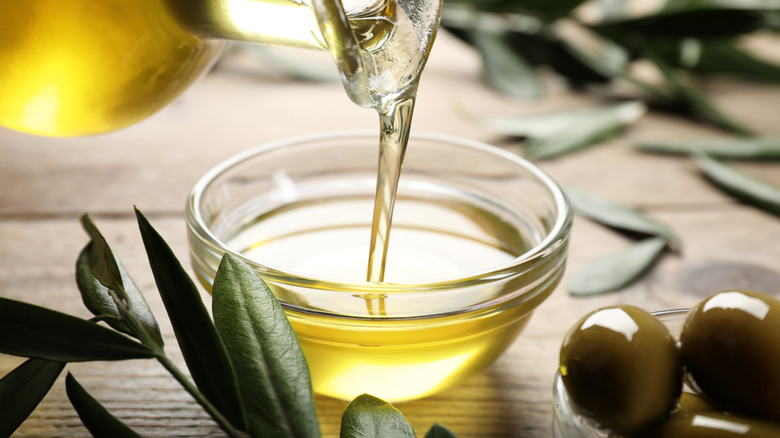 Pouring olive oil into a glass bowl