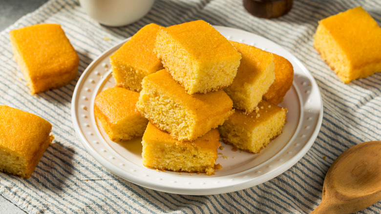 A plate of bright yellow cornbread slices, cut to show their spongy interior