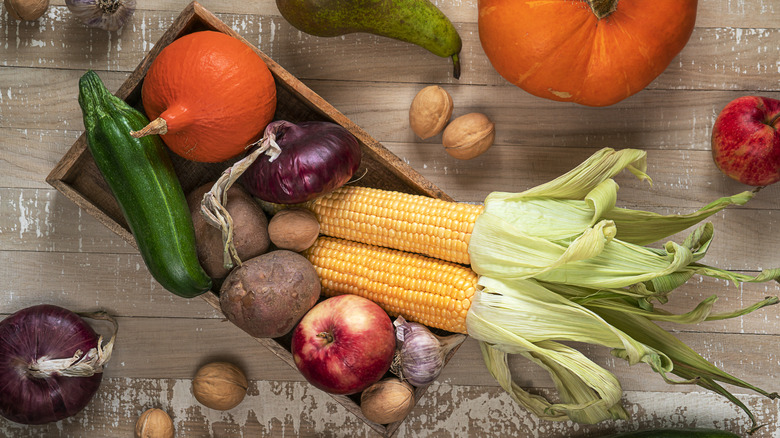 A wooden box holding fresh produce native to the Americas, often used in Indigenous American dishes