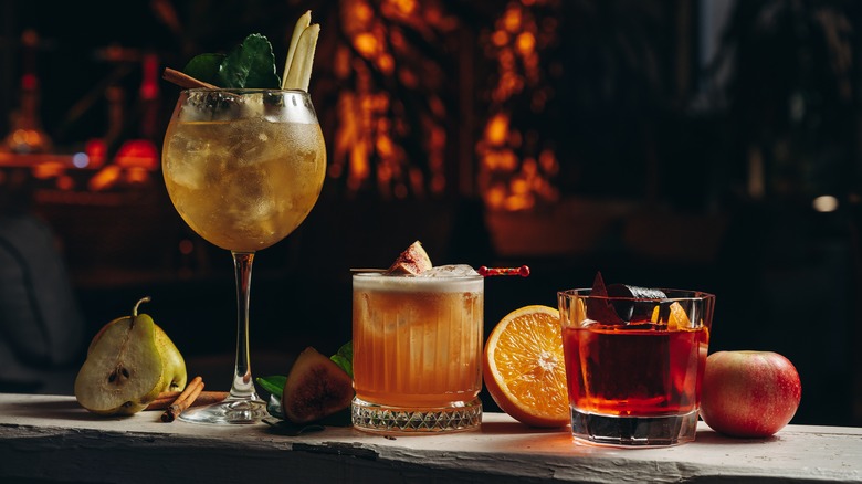 three colorful cocktails sit on a bar