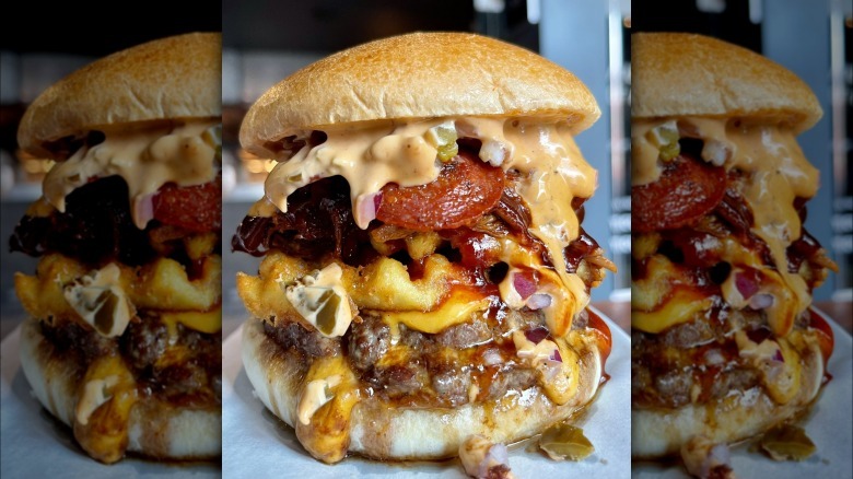 Almost Famous burger with french fries, lots of sauce, and other toppings