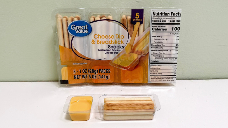 Great Value Cheese Dip and Breadstick Snacks packaging behind an opened cheese dip snack