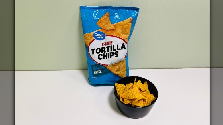 A bag of Great Value Crunchy Tortilla Chips beside a bowl of tortilla chips