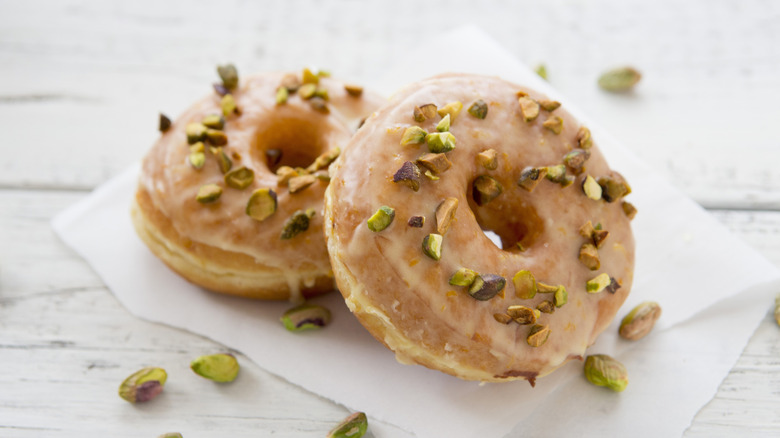 Glazed donut topped with pistachios