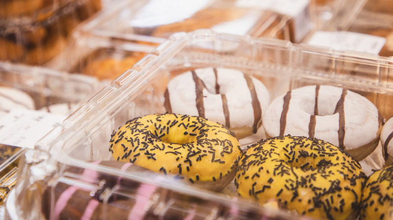 Plastic containers of frosted donuts