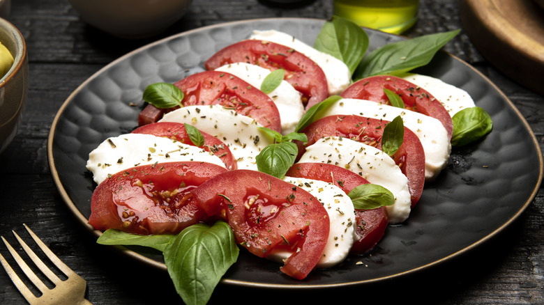 Caprese salad on a black plate