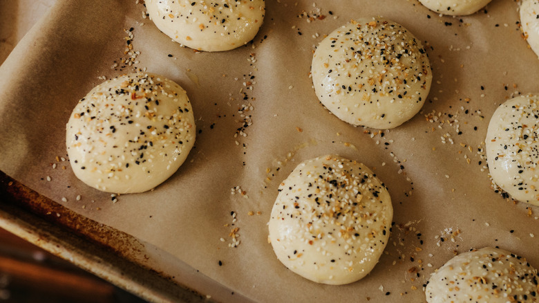Unbaked sourdough buns topped with everything bagel seasoning