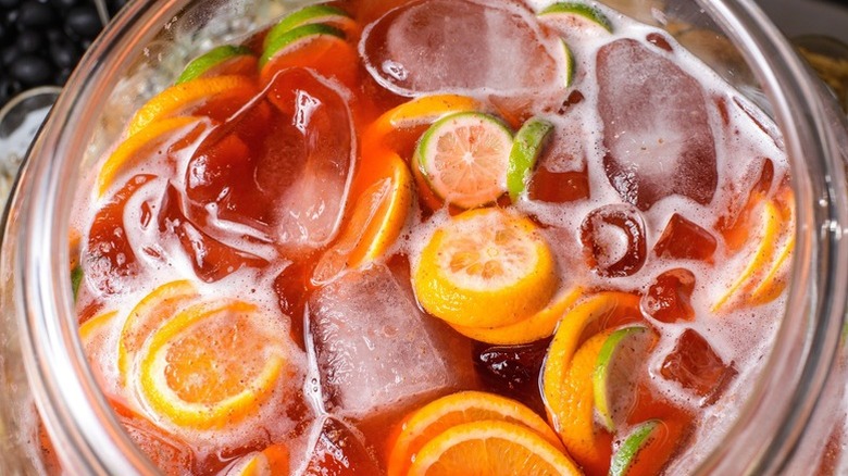 Closeup of a very merry crush cocktail showing ice cubes and citrus slices
