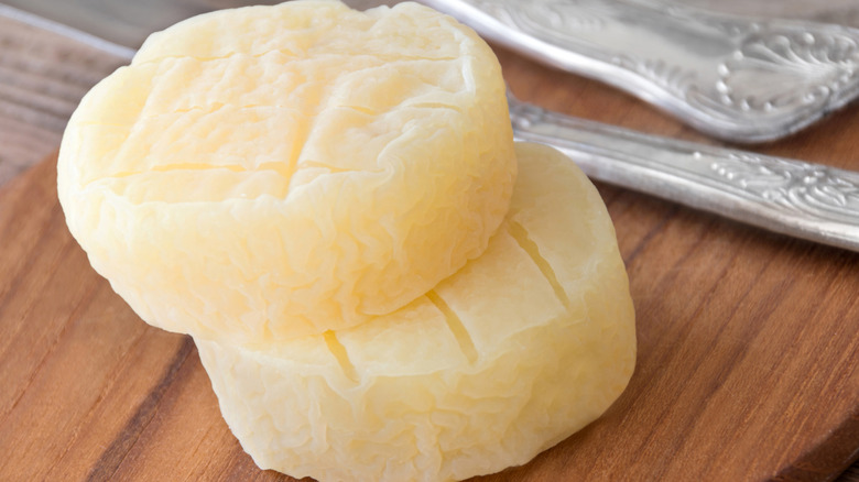 Two rounds of harzer cheese on a wooden table