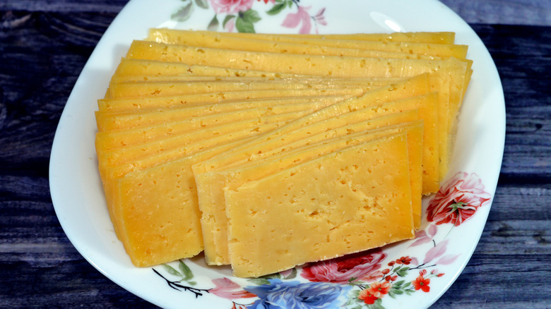 Thin slices of roumy cheese on a floral plate