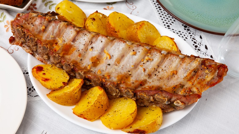 White platter of costillas with potatoes