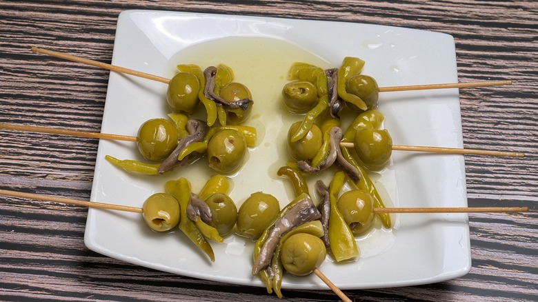 Square white plate filled with gildas pintxos
