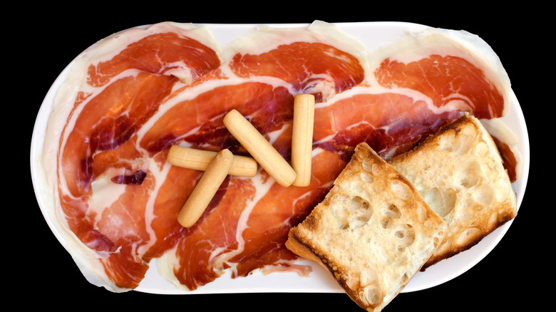 White platter with jamón Iberico and crusty bread