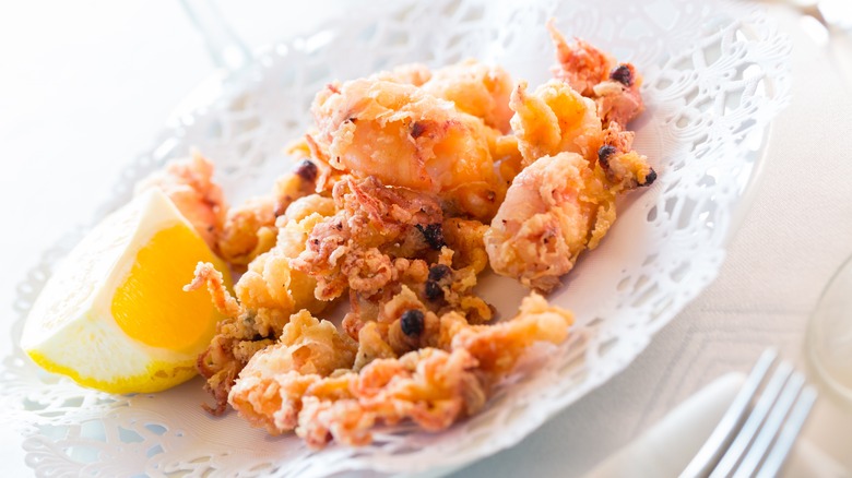 White platter of pescaíto frito with slice of lemon