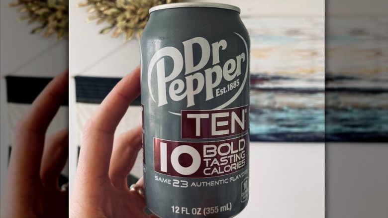 Hand holding can of Dr Pepper Ten