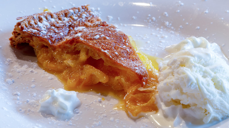 Slice of Shaker lemon pie on a white plate with whipped cream