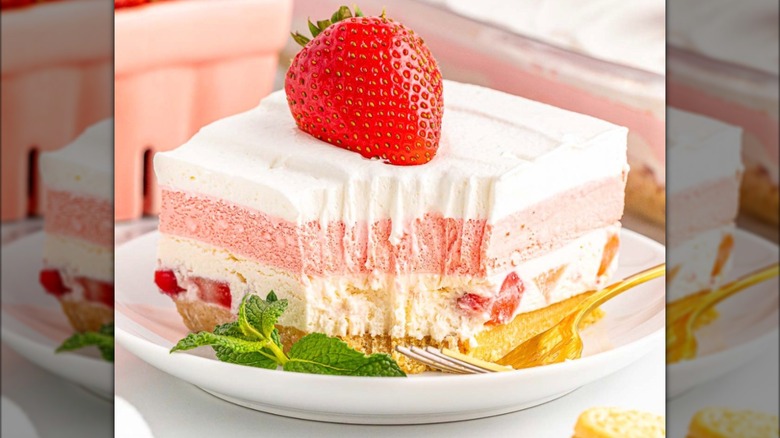 Strawberry delight dessert on a white plate garnished with whole strawberry