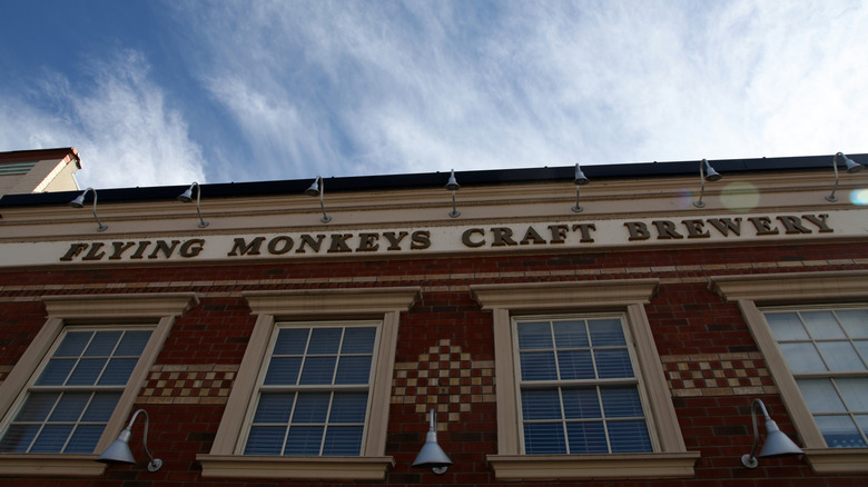 The outside of the Flying Monkeys Craft Brewery, a plain-looking brick facade with cream-colored accents