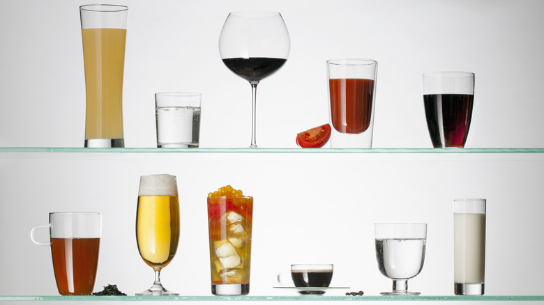 A variety of beverages on glass shelves against a white background