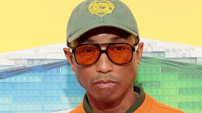 Pharrell Williams poses at event