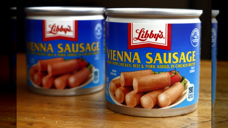 Two cans of Libby's Vienna sausages on wooden table