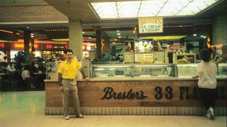 old photo of Bresler's Ice Cream and Yogurt shop and man standing nearby