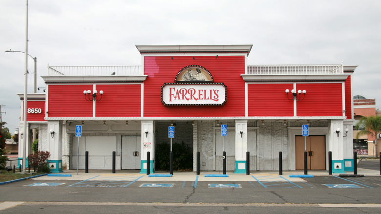 The outside of a Farrell's ice cream parlour, a red building and an empty parking lot