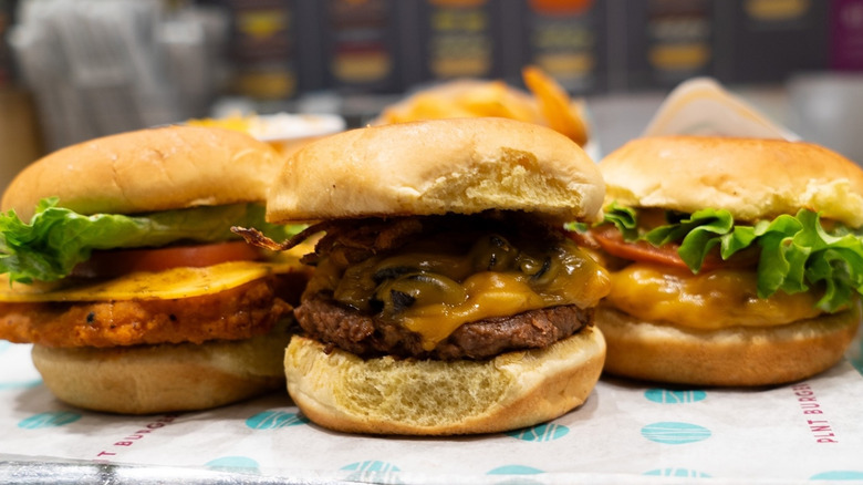 Three vegan sandwiches lined up on tissue at fast food restaurant